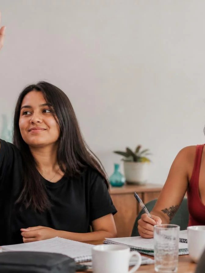 Dupla preparando uma rodada com cadernos abertos e canetas marcadoras sobre a mesa